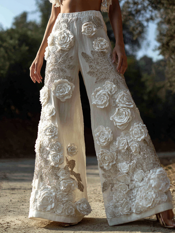 Pantalon long ample à jambes larges en coton et lin, style bohème, orné de broderies roses en relief. 